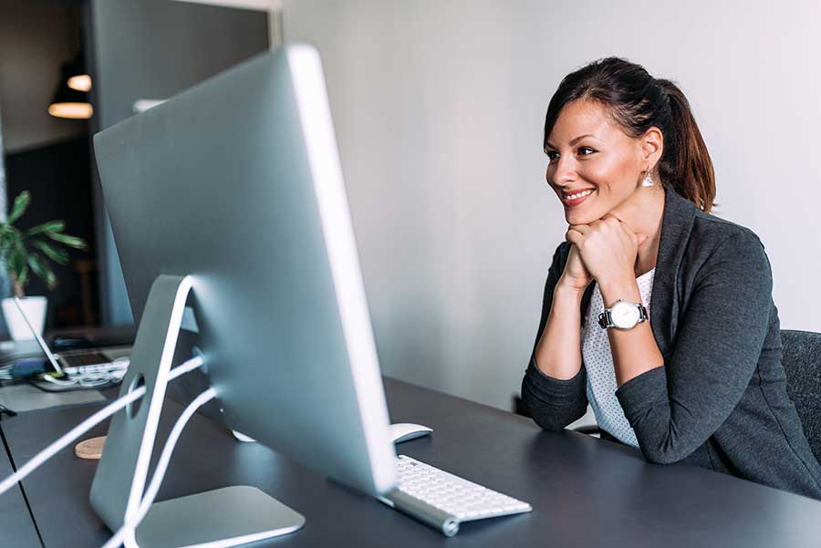 Happy woman reading subtitles on screen in office