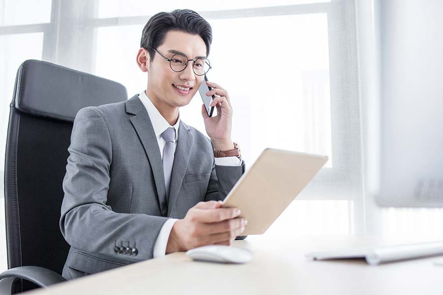 Chinese-businessman Chinese businessman on phone and laptop in office