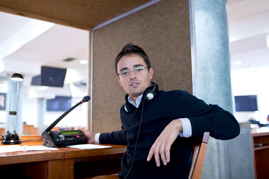 Man with glasses in interpreting booth. 
